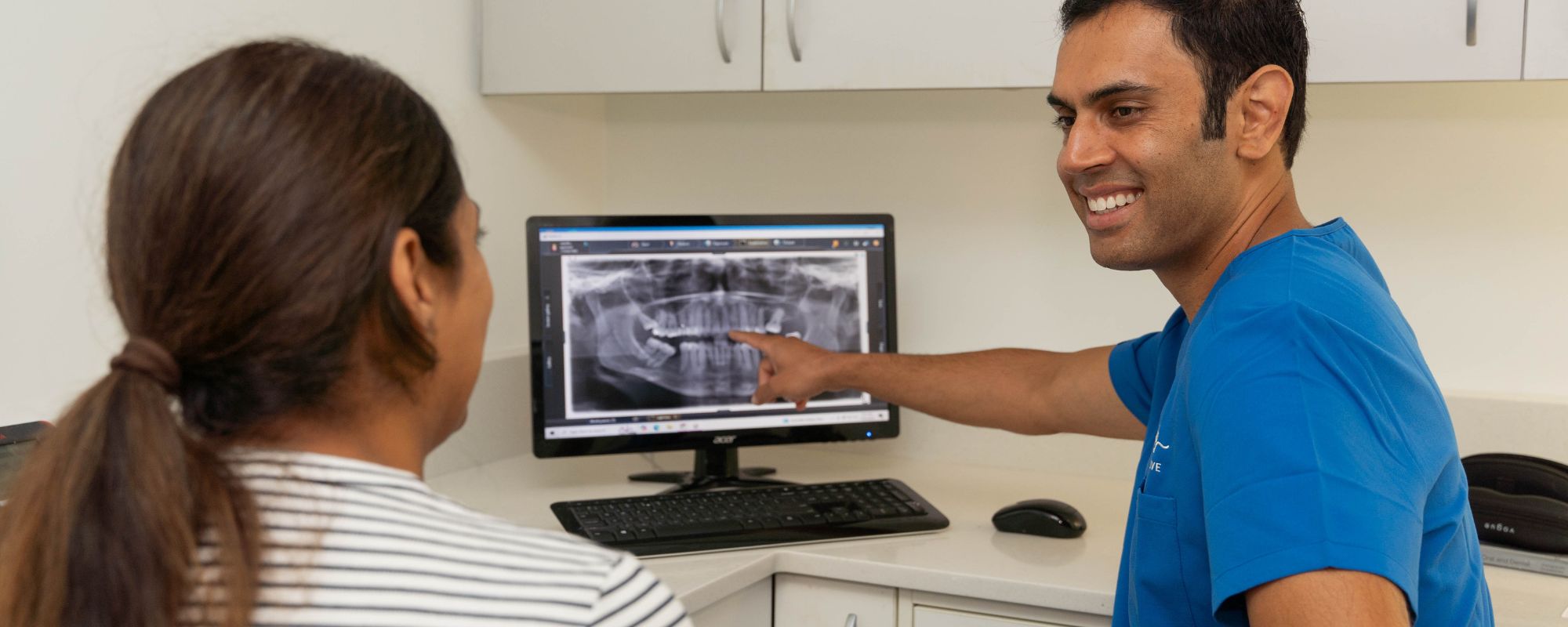 Dr Sundeep Suaan showing a patient an X-ray on screen